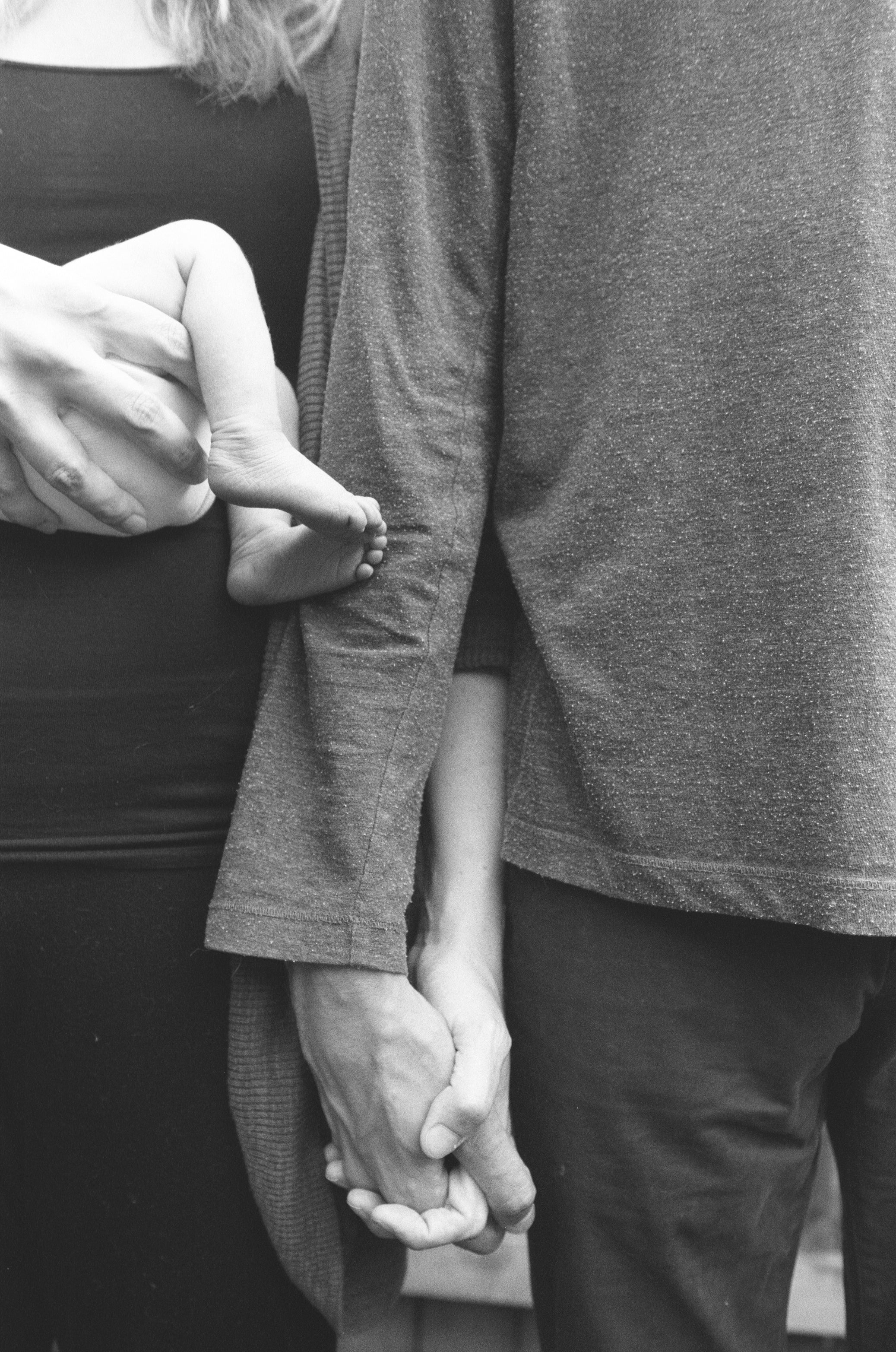 files/while-cradling-a-babies-bottom-a-couple-holds-hands.jpg